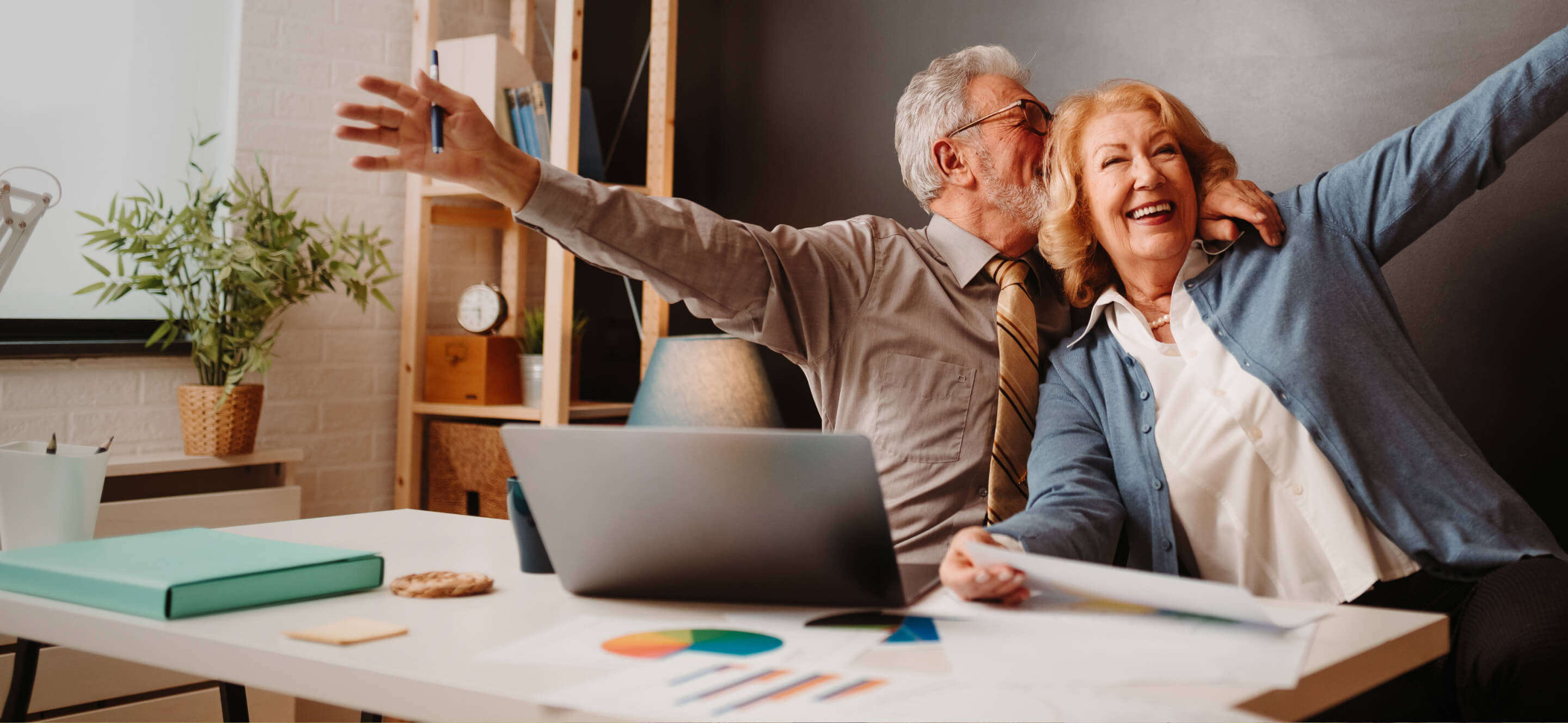 Pareja senior feliz delante de un ordenador